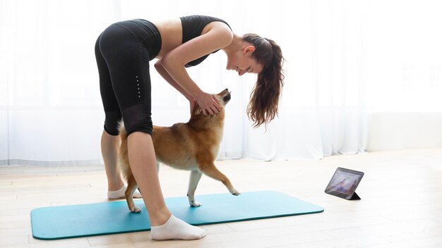 犬と一緒に運動する若い女性