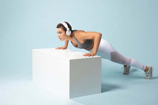 Free photo young woman exercising with her headphones on