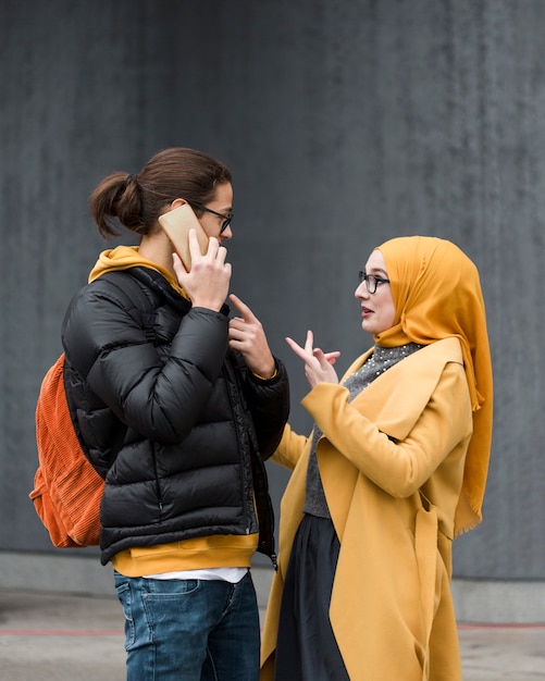 Free photo young woman explaining something to her friend