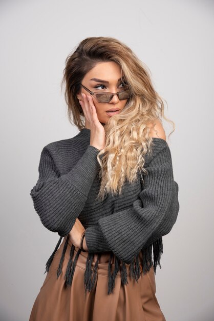 Young woman in eyeglasses looking at her side.