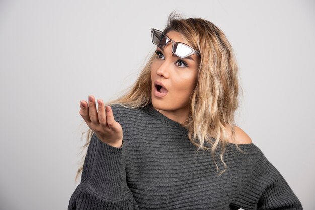 Free photo young woman in eyeglasses looking shocked about something.