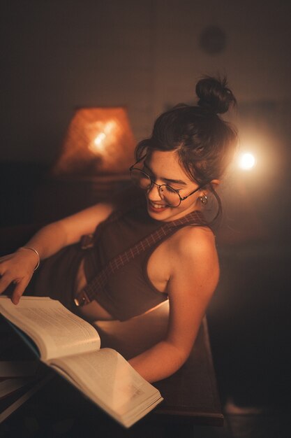 아늑한 거실에서 책을 읽는 안경을 쓴 젊은 여성