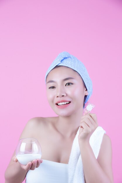 Young woman face mask pad pink background.