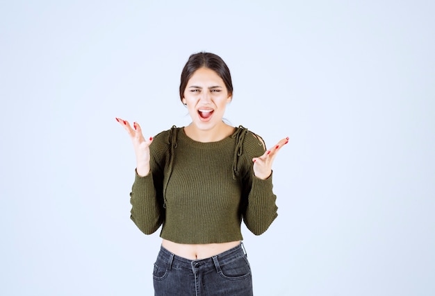 young woman feeling angry and screaming on white background.