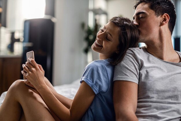 Young woman feeling happy while spending time with her boyfriend who is kissing her