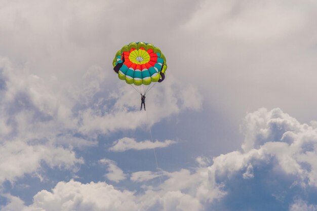 若い​女性​は​雲​の​間​で​パラシュート​で​飛ぶ​。