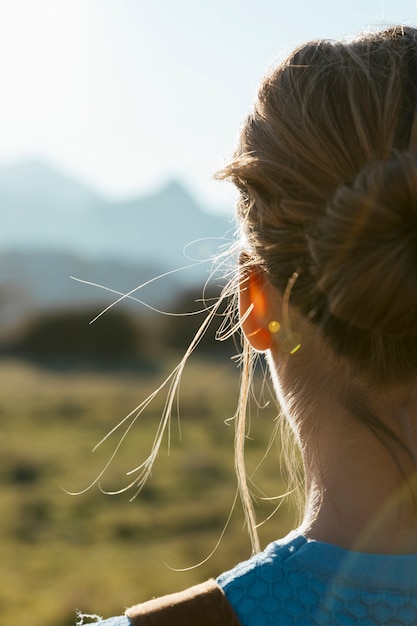 Young woman from behind facing sun