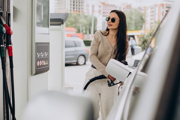彼女の車に燃料を供給する若い女性