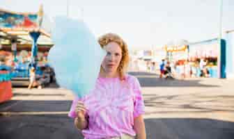 Free photo young woman at funfair with cotton candy