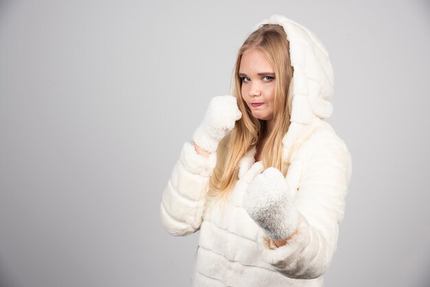 Young woman in fur coat giving punches.