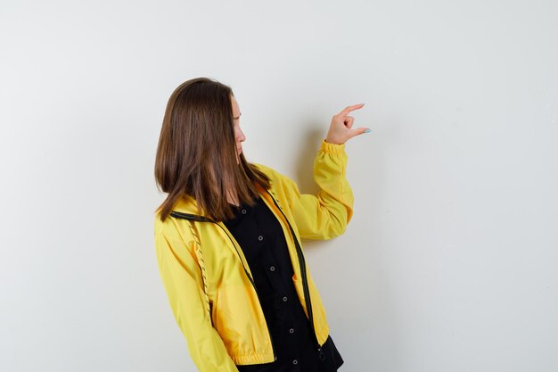 Young woman gesturing small size with her fingers