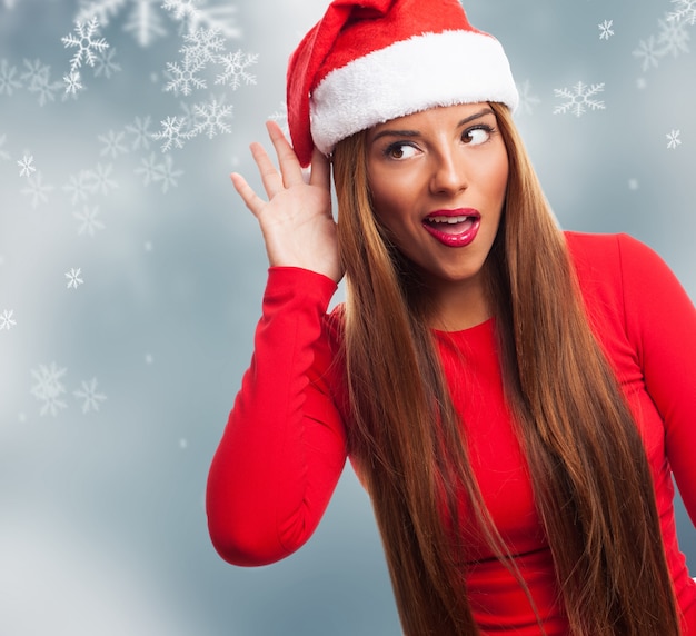 Young woman gesturing with her hand on christmas background