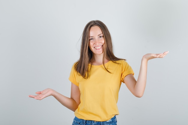 手のひらで身振りで示す若い女性、Tシャツで決定しようとしています