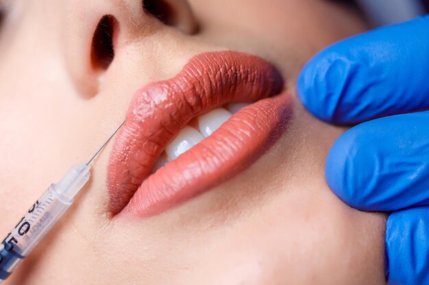 若い女性は彼女の唇にボトックス注射を受けます。ビューティーサロンの女性。形成外科クリニック。