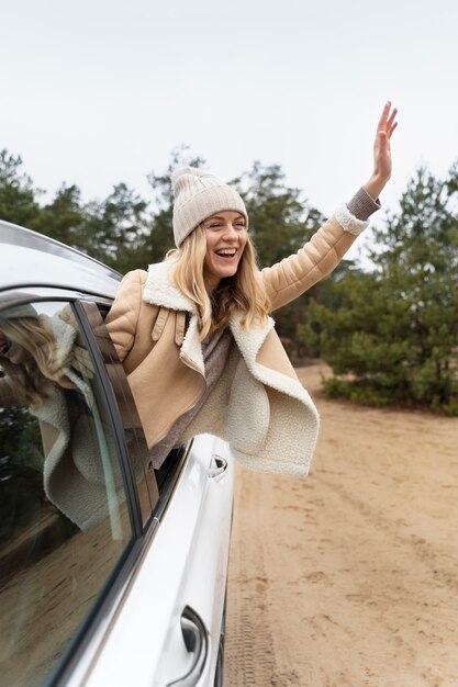 旅行中に窓の車の外に出る若い女性