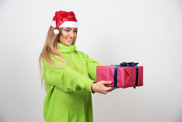 Young woman giving a festive Christmas present.