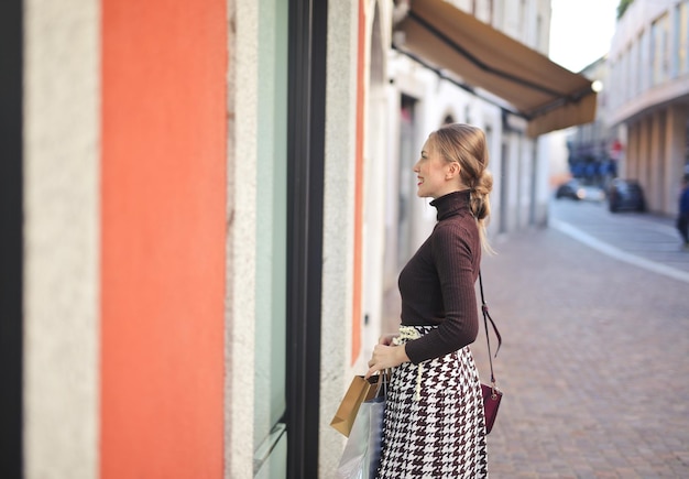 Бесплатное фото Молодая женщина ходит по магазинам в городе