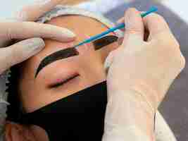 Free photo young woman going through a microblading procedure