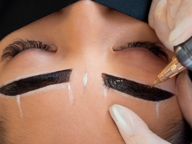 Free photo young woman going through a microblading procedure