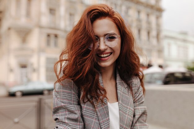 Young woman in good humor poses outside