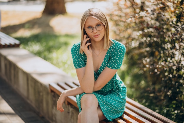 Young woman in green dress sitting in park