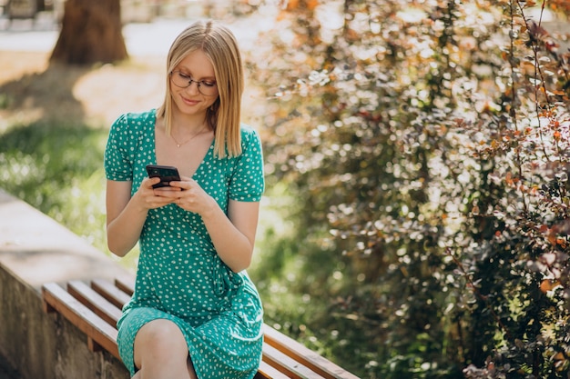 Young woman in green dress sitting in park