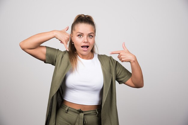 Young woman in green shirt calling someone.