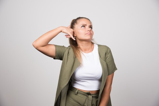 Young woman in green shirt calling someone.