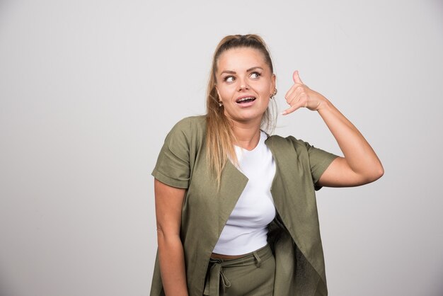 Young woman in green shirt calling someone.