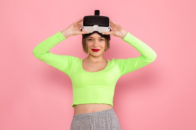 young woman in green shirt and grey skirt smiling trying out virtual reality