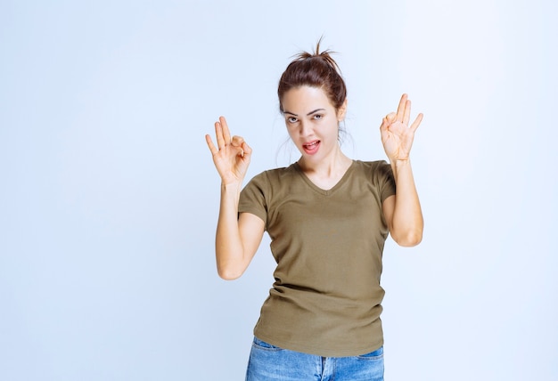 Young woman in green shirt showing enjoyment sign