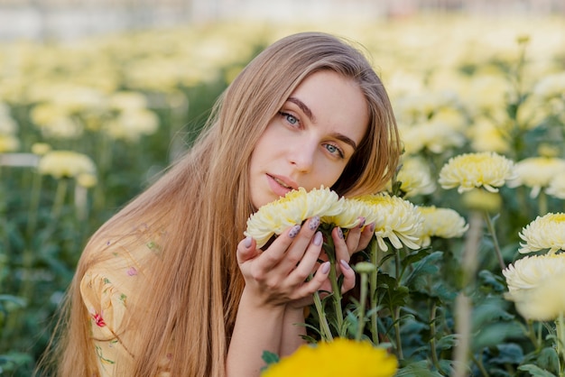 Free photo young woman in a greenhouse with flowers