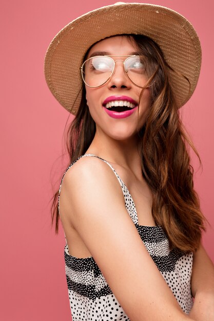 Young woman in grey dress with hat and glasses