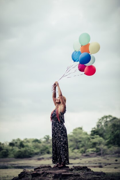 Young woman hand holding colorful balloons