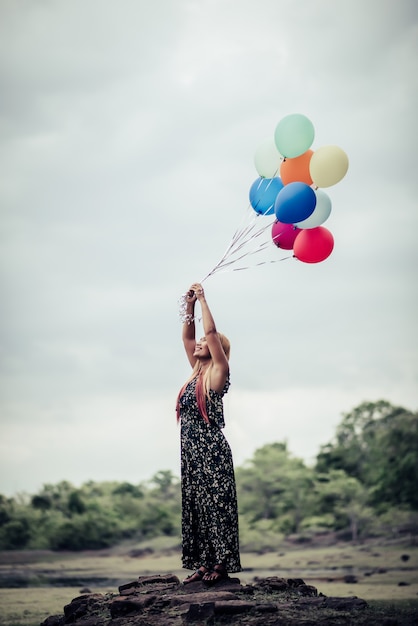Молодая женщина рука проведение красочные воздушные шары
