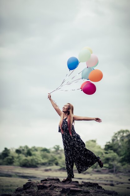 Young woman hand holding colorful balloons