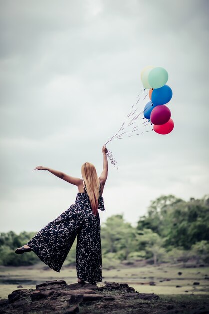 Young woman hand holding colorful balloons