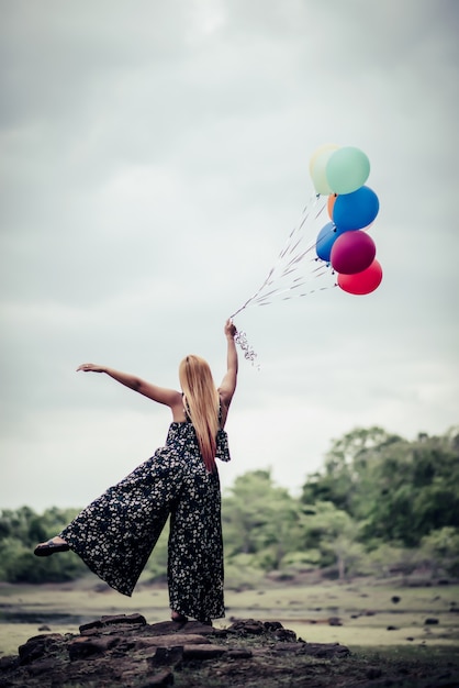 Young woman hand holding colorful balloons