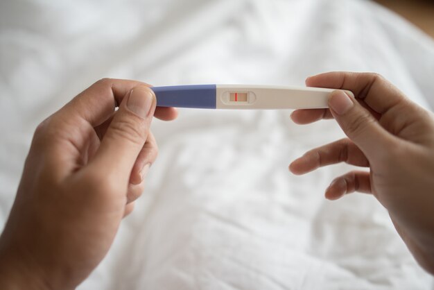 Young woman hand holding pregnancy test 