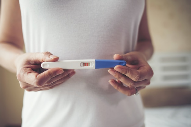 Young woman hand holding pregnancy test 