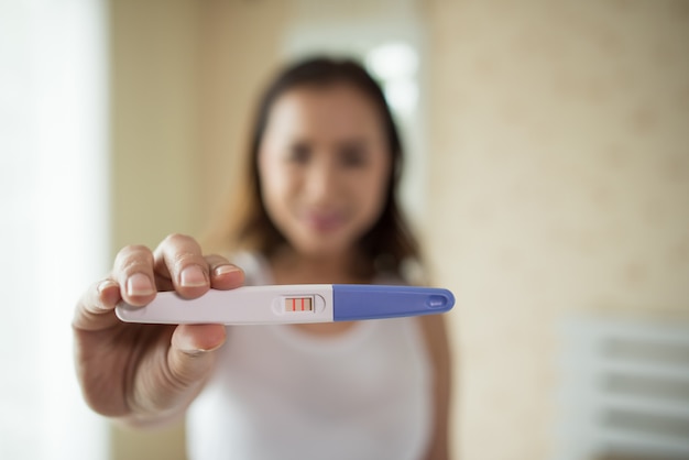 Young woman hand holding pregnancy test 