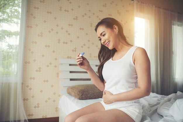 Young woman hand holding pregnancy test 