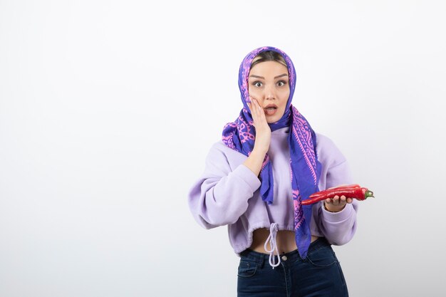 young woman in handkerchief holding a red pepper