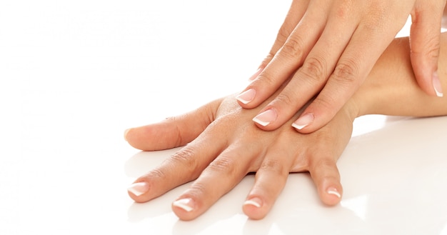 Mani di giovane donna con manicure francese