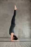 Free photo young woman in handstand exercise