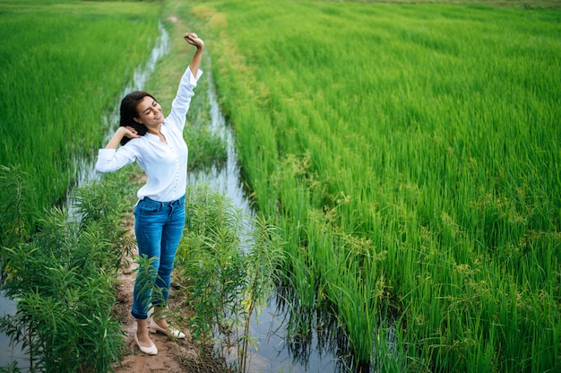 Young woman happily in a green field at sunny day