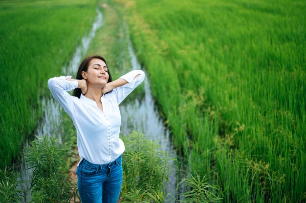 Young woman happily in a green field at sunny day