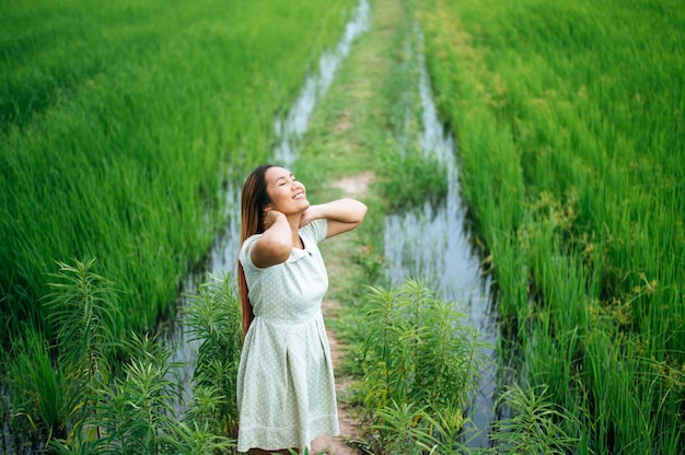 Молодая женщина счастливо в зеленом поле в солнечный день
