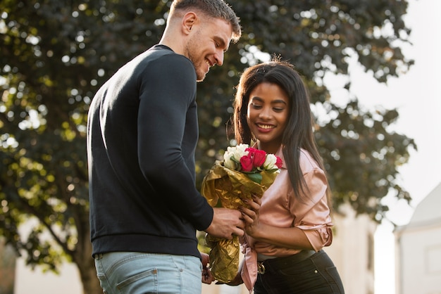 無料写真 彼女のボーイフレンドからバラの花束を持っている若い女性