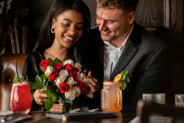 彼女のボーイフレンドからバラの花束を持っている若い女性